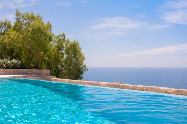 Azure blue clear pool against the backdrop of sea and sky. — Stock Photo, Image