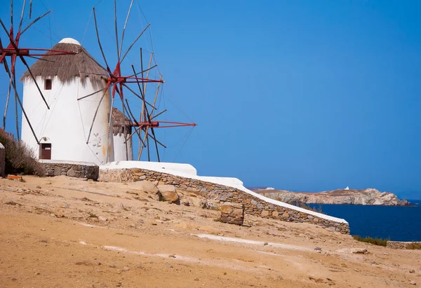 Windmolens op een heuvel in de buurt van de zee op het eiland mykonos — Stockfoto