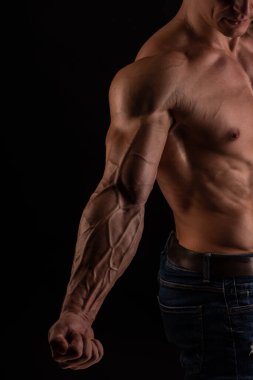 Kaslı erkek model kaslarını esnetiyor. 