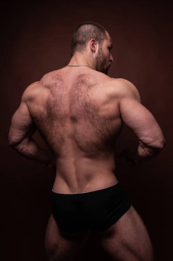 Sırtını gösteren kaslı erkek model.