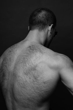 Sırtını gösteren kaslı erkek model.