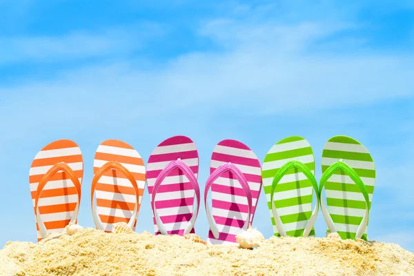 Playa de verano con sandalias multicolores — Foto de Stock