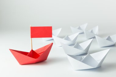 Beyaz arasında önde gelen kırmızı kağıt gemi ile liderlik kavramı
