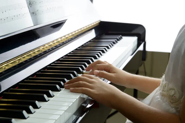 Lilla flicka spelar piano — Stockfoto