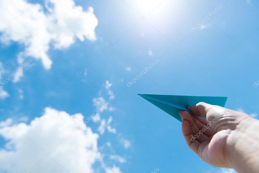 Paper plane against cloudy sky