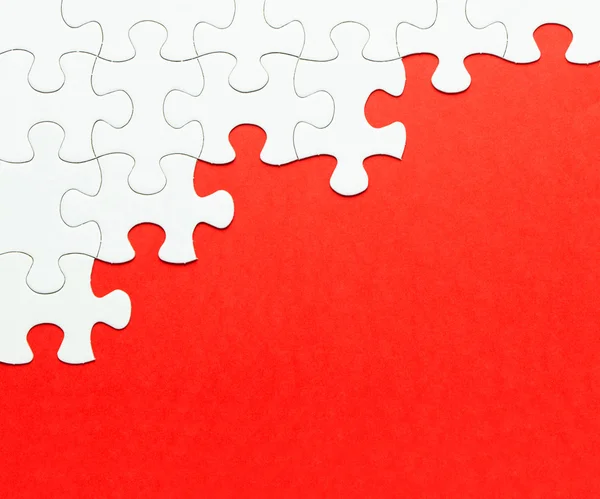 White jigsaw puzzle on red background — Stock Photo, Image
