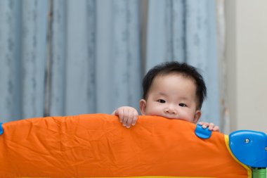 Asian baby in playpen clipart