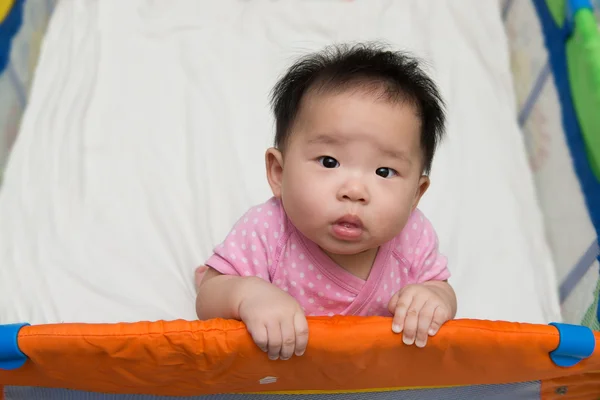 Aziatische baby in kinderbox — Stockfoto