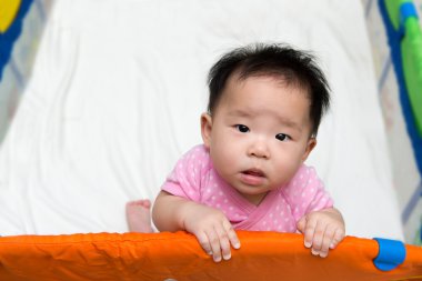 Asian baby in playpen clipart