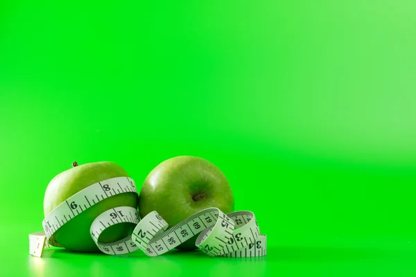 Green apple with a tape measure — Stock Photo, Image