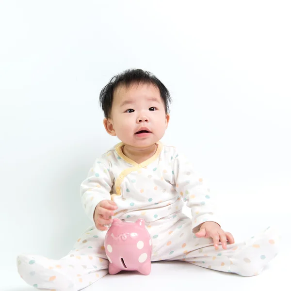 Asiatisches Baby mit Sparschwein — Stockfoto