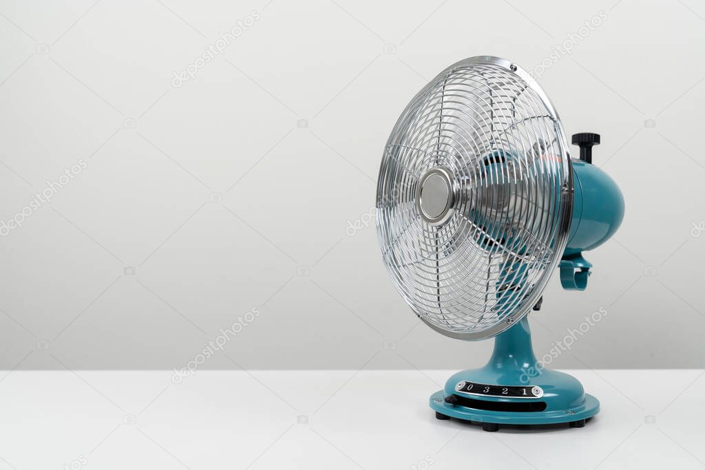 Vintage blue tabletop fan isolated on a white background