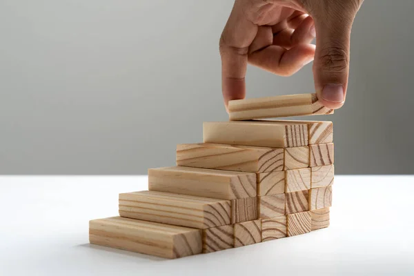 Hand arranging wood block stacking as step stair — Stock Photo, Image