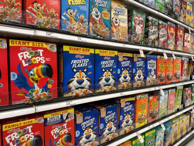 Northville, Michigan, ABD - 16 Kasım 2025: Kelloggs Froot Loops, Frosted Flakes ve diğer popüler markalarla dolu bir market koridoru, raflarda parlak, göz alıcı sıralarda dizilmiş.