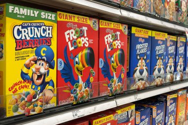 Northville, Michigan, ABD - 16 Kasım 2025: Kelloggs Froot Loops, Frosted Flakes ve diğer popüler markalarla dolu bir market koridoru, raflarda parlak, göz alıcı sıralarda dizilmiş.