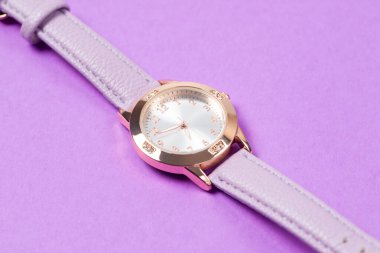 Gül sarısı çantalı şık bir kadın kol saati, minimalist kadranı, ve yumuşak lavantalı mor deri kayışı. Gündelik kıyafetler için modern moda ve zarafetin mükemmel bir karışımı..