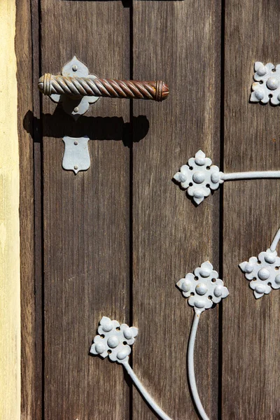 Old metal door handle on wood boarded door in Wurzburg, Germany.