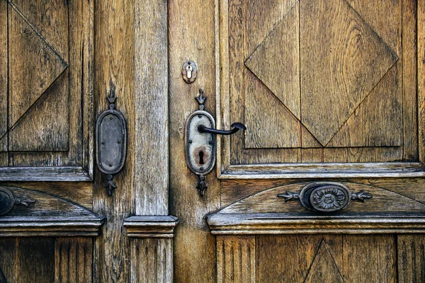 Old metal door handle and metal decor on wood door in Wurzburg, Germany.