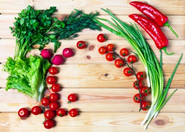 Taze sebzeler, kırmızı kiraz domatesleri yeşil soğan, ahşap tahtada maydanoz. Düz düzen, üst görünüm.