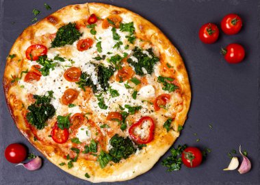 Siyah tahtada ıspanaklı pizza ve mozzarella. Düz dizayn, üst görünüm.