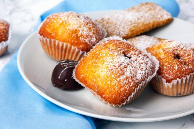 Beyaz tabakta krema şekerli mini kekler. Seçici odak. 