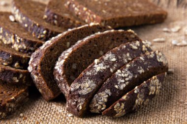 Ayçekirdeği ve keten tohumlarıyla pişirilmiş siyah çavdar ekmeği dilimleri. Seçici odak.