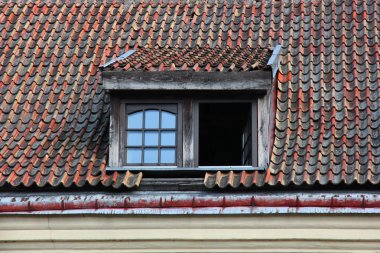 Windows in attic of old tiled roof.  clipart