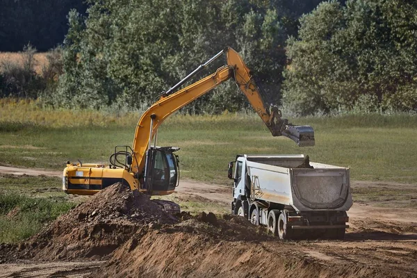 Byggarbetsplatsens grävmaskin och lastbil — Stockfoto