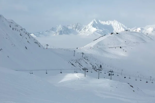 꼭대기에서 스키를 타고 가는 눈덮인 산비탈 — 스톡 사진