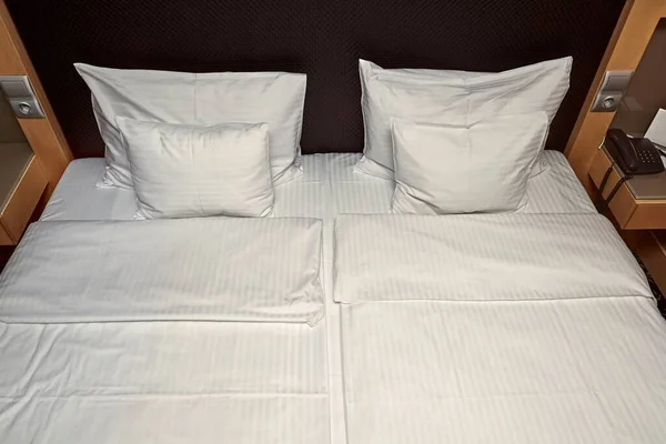 Cama de hotel con sábanas blancas — Foto de Stock