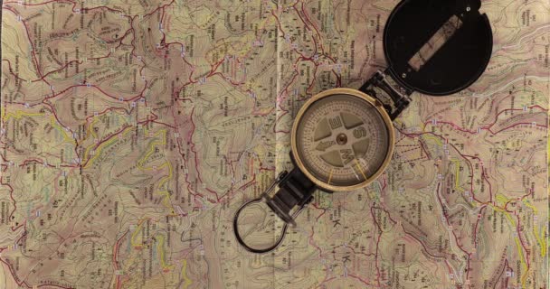 Kompass snurrar över en vandringskarta — Stockvideo