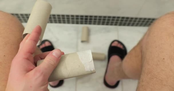 Нахождение только пустых рулонов туалетной бумаги, сидящих на унитазе — стоковое видео
