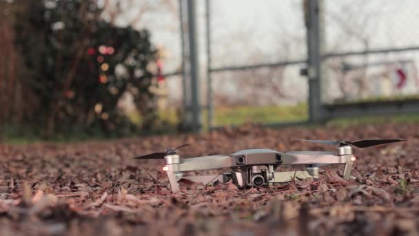 Drone soplando hojas de otoño al despegar — Vídeos de Stock