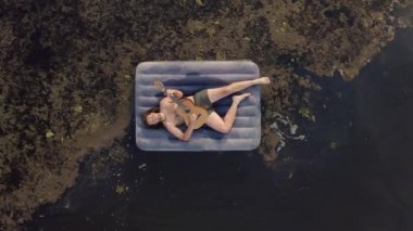 Bir yatakta gölde gitar çalmak.