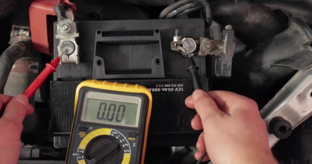Sprawdzanie napięcia akumulatora samochodowego i alternatora z pracującym silnikiem — Wideo stockowe