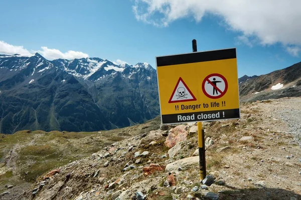 Camino en la montaña cerrado con señal de advertencia — Foto de Stock