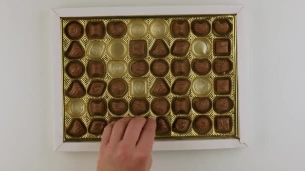 Prendendo pezzi di caramelle dalla scatola di bonbon — Video Stock