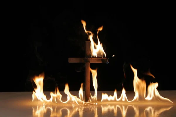 Fuego alrededor de un símbolo de cruz ardiente — Foto de Stock