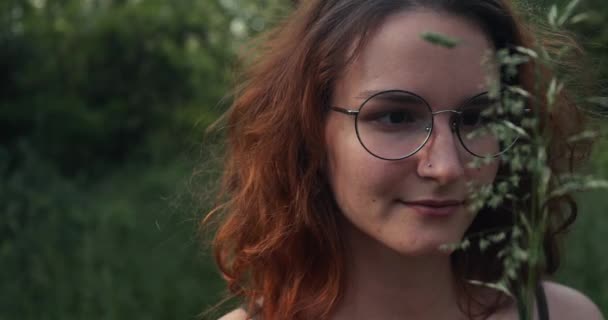 Az erdei ösvényen sétáló lány növényeket néz — Stock videók