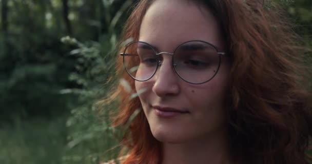 Menina andando em um caminho da floresta olhando para as plantas — Vídeo de Stock