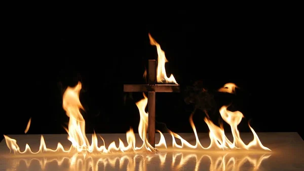 Fuego alrededor de un símbolo de cruz ardiente —  Fotos de Stock
