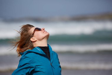 Deniz kenarındaki rüzgârdan hoşlanan kadın