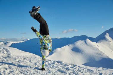Freeride skier doing hand stand on the peak clipart