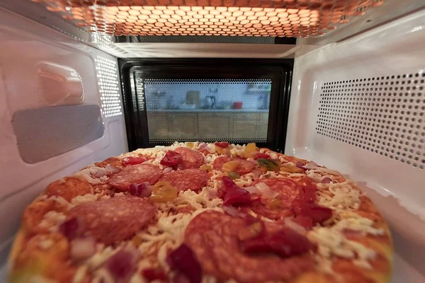 Calefacción de pizza en un horno de microondas —  Fotos de Stock