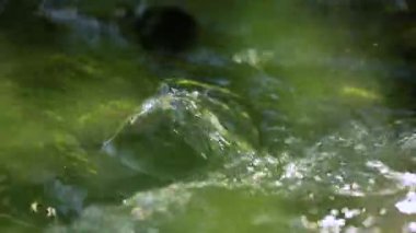 Small mountain stream, fresh cool and clean water splashing on rock, nature, closeup detail slow motion from 120fps footage in 60p 60 fps, pristine nature