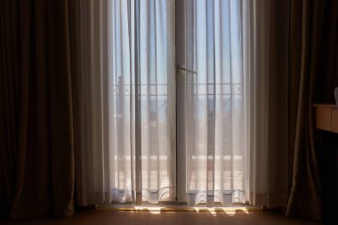 Deniz manzaralı, balkon kapılı yaz güneşli deniz kenarında perdesi olan oda.