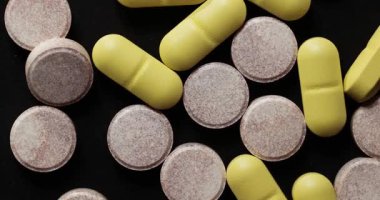 Siyah arka planda dönen ilaç ya da ilaç hapları