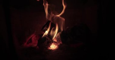 Şömine, şömine odunları ateşin yanında sakin sıcak bir atmosfer.