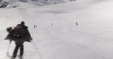 Alplerde kayak yapmak, kayakçı hızla aşağı inmek, yavaş yamaçlarda dinamik takip çekimi