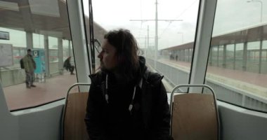 Sabah tramvayda oturan bir adam Ostrava 'da toplu taşıma araçlarıyla işe giderken duraktan geçiyor.